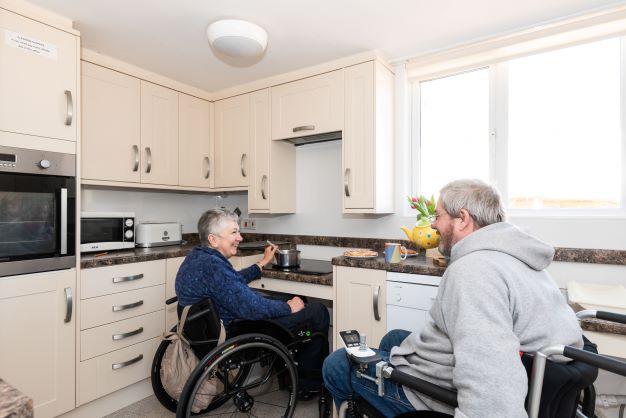 Kitchen with height adjustable hob and sink